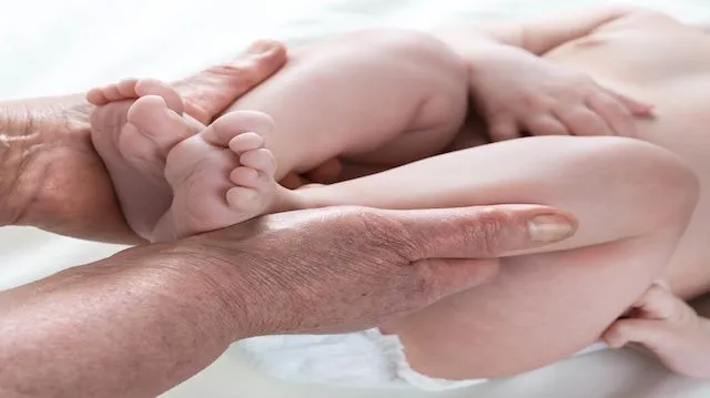 .Grandma's hands taking care of the baby , soft skin